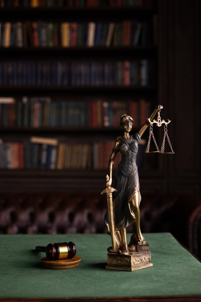 Lady Justice and gavel on a table in a classic law library setting.